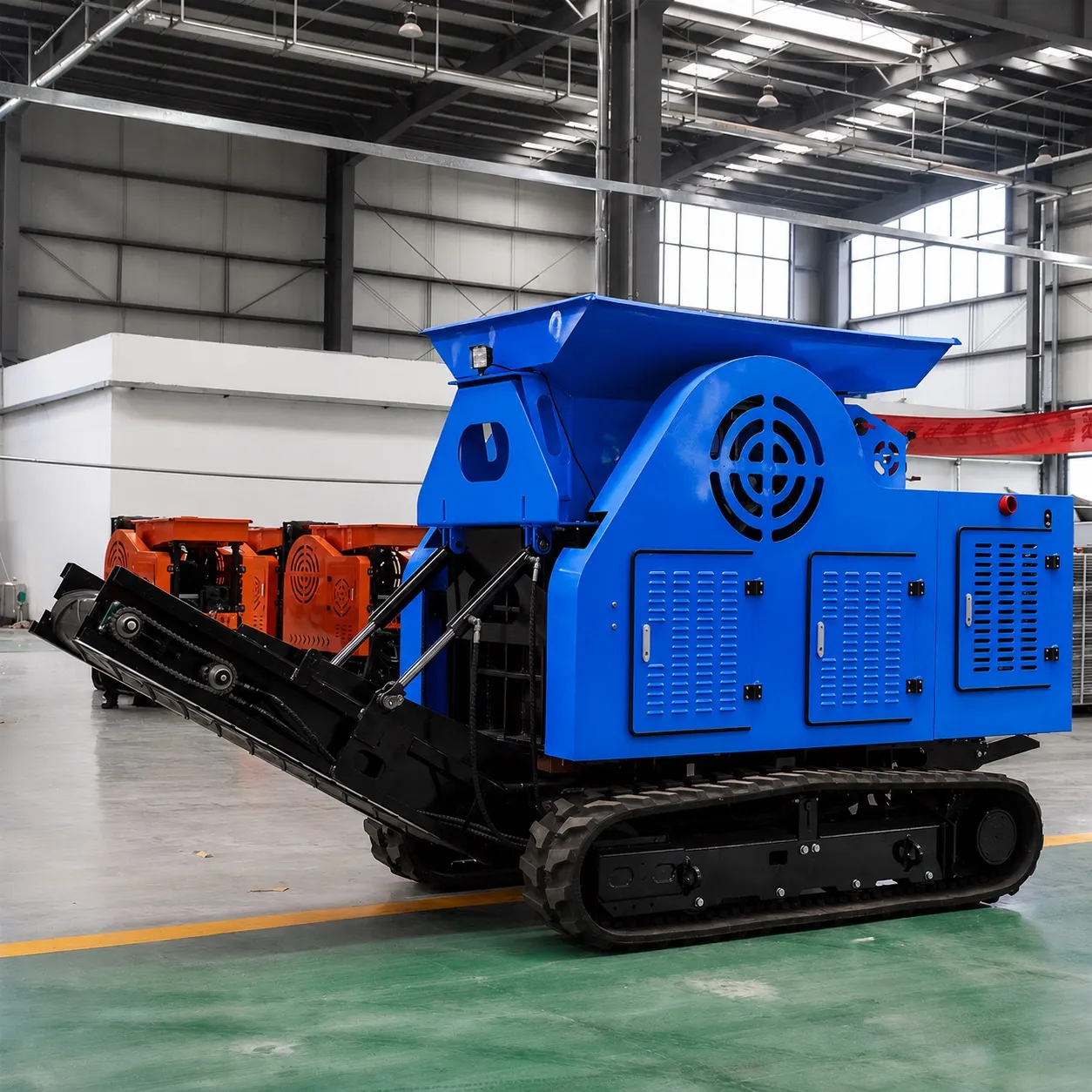 Mobilní drtička Crusher v modrém provedení na pásovém podvozku s vyklopeným pásovým dopravníkem